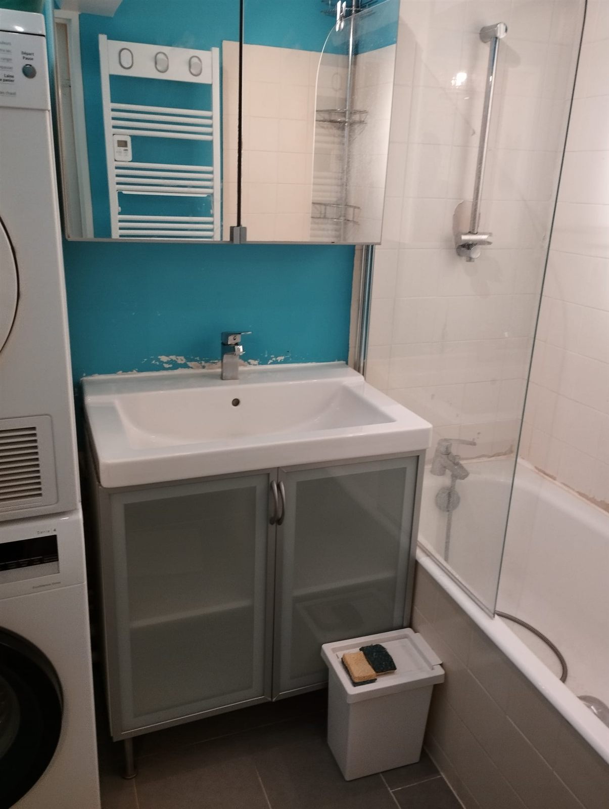 Salle de bain avant rénovation, murs abîmés et ancienne baignoire