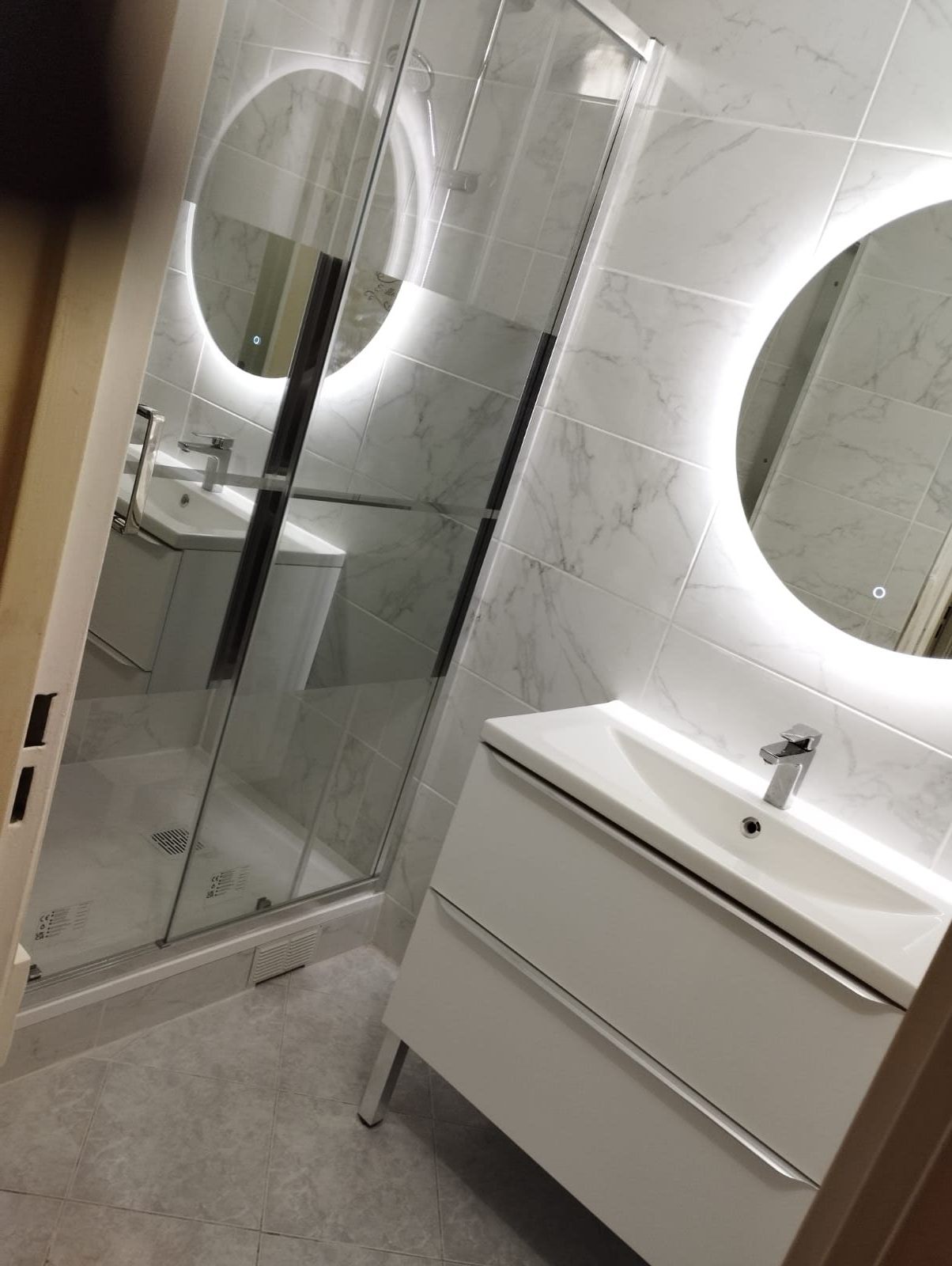 Salle de bain en marbre avec douche vitrée